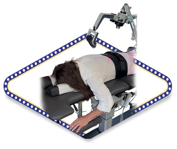 A patient receiving non-surgical laser therapy on a specialized chiropractic table with a mechanical traction device, framed by a diamond-shaped border with blue lights.