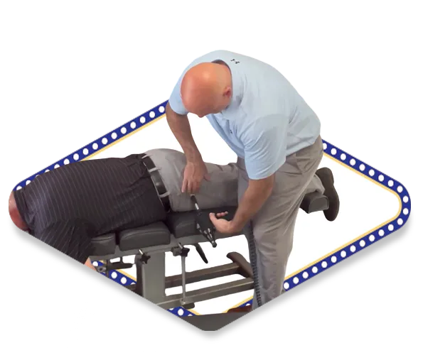 Dr. Dale Kimberlin using chiropractic adjustment tool to treat male patient's sciatica and nerve pain at Kimberlin Chiropractic Health Systems in Ankeny Iowa.