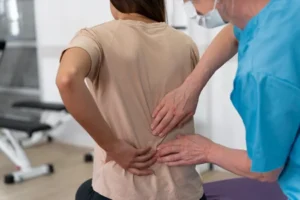 Chiropractic assistant helping patient with physiotherapy exercises